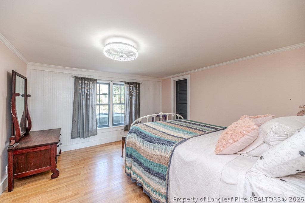 509 Carthage Street Cameron, NC 28326 - Photo 13 of 43 a spacious bedroom with a bed and wooden floor