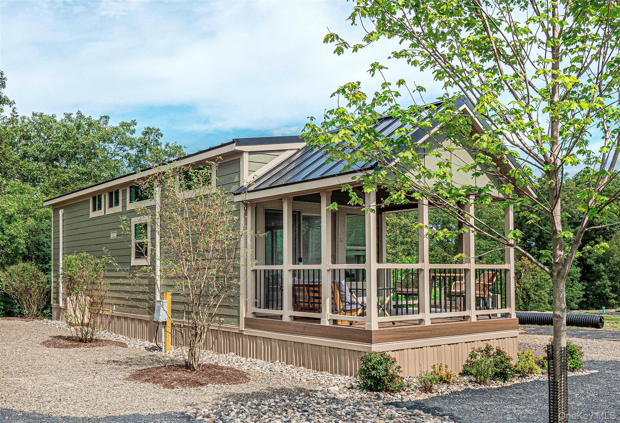 The Appalachian Model. A view of home's exterior with a metal roof, a standing seam roof, and covered porch