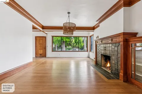 a view of an empty room with wooden floor fireplace and a window