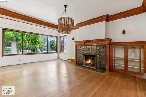 a view of an empty room with wooden floor fireplace and a window