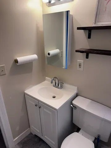 a white toilet sitting next to a bathroom sink