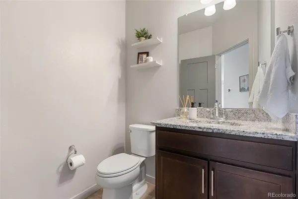 a bathroom with a granite countertop toilet sink and mirror