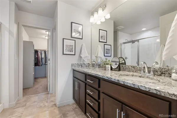 a bathroom with a granite countertop sink a mirror and a shower