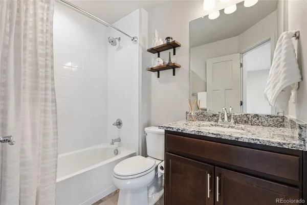 a bathroom with a granite countertop sink toilet and shower