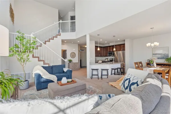 a living room with furniture and a view of kitchen