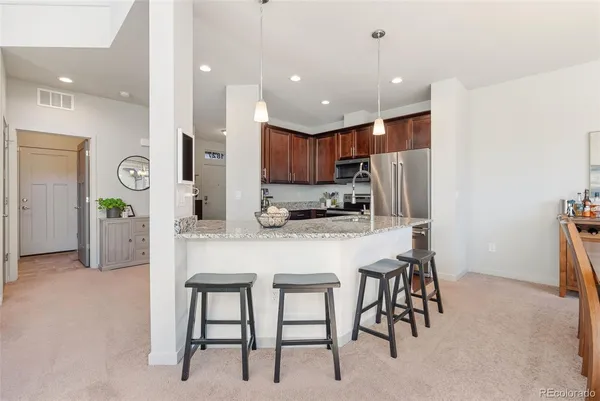 a kitchen with kitchen island cabinets and chairs in it
