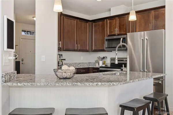 a kitchen with stainless steel appliances granite countertop a refrigerator and a stove top oven