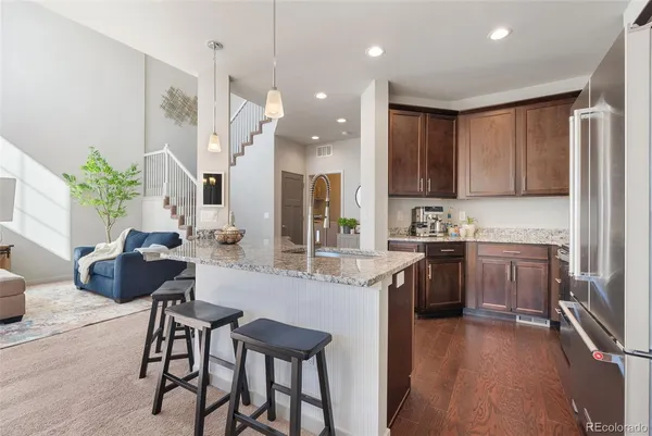 a kitchen with kitchen island granite countertop wooden cabinets and stainless steel appliances