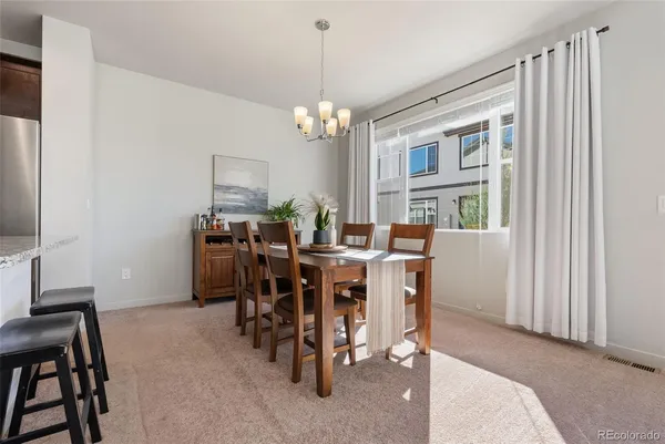 a dining room with furniture a chandelier and window