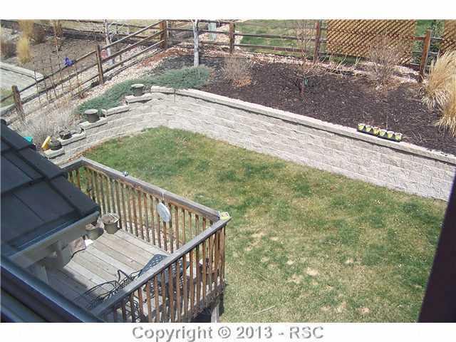 812 Spectrum Loop Colorado Springs, CO 80921 - Photo 16 of 17 Roomy deck and professionally landscaped back yard w/ retaining wall.