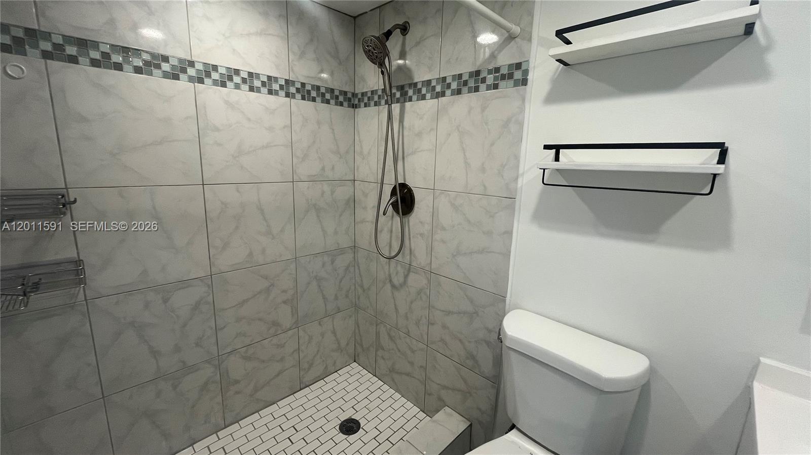 8540 Southwest 133rd Avenue Road, Unit 316 Miami, FL 33183 - Photo 11 of 18 a bathroom with a shower and a toilet