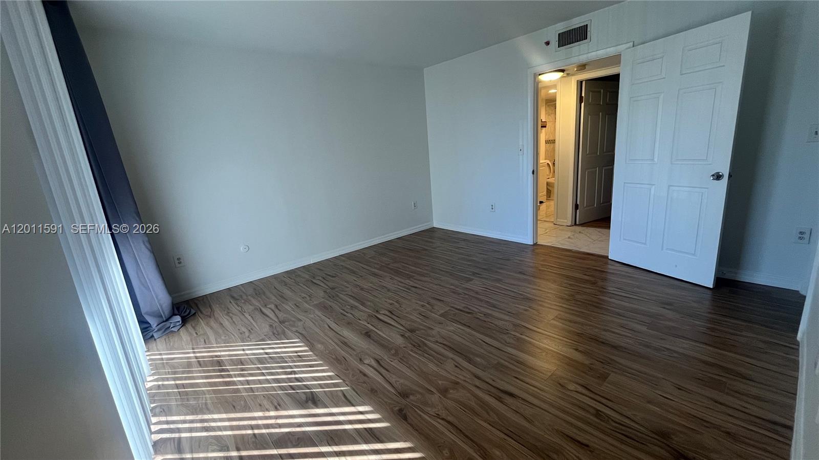 8540 Southwest 133rd Avenue Road, Unit 316 Miami, FL 33183 - Photo 13 of 18 an empty room with wooden floor and entrance