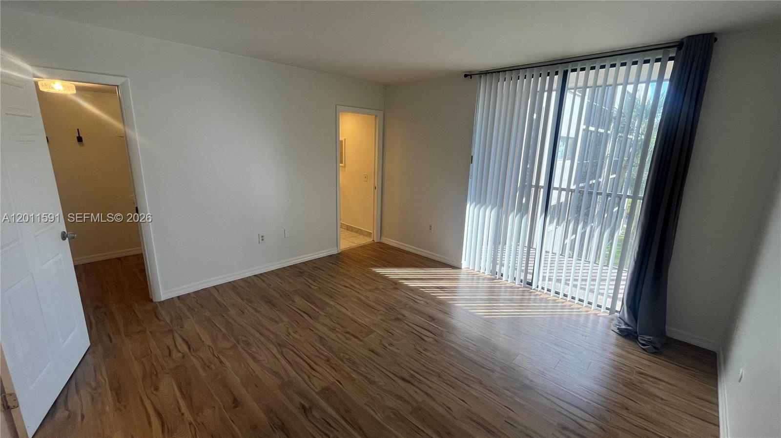 8540 Southwest 133rd Avenue Road, Unit 316 Miami, FL 33183 - Photo 15 of 18 an empty room with wooden floor and a window