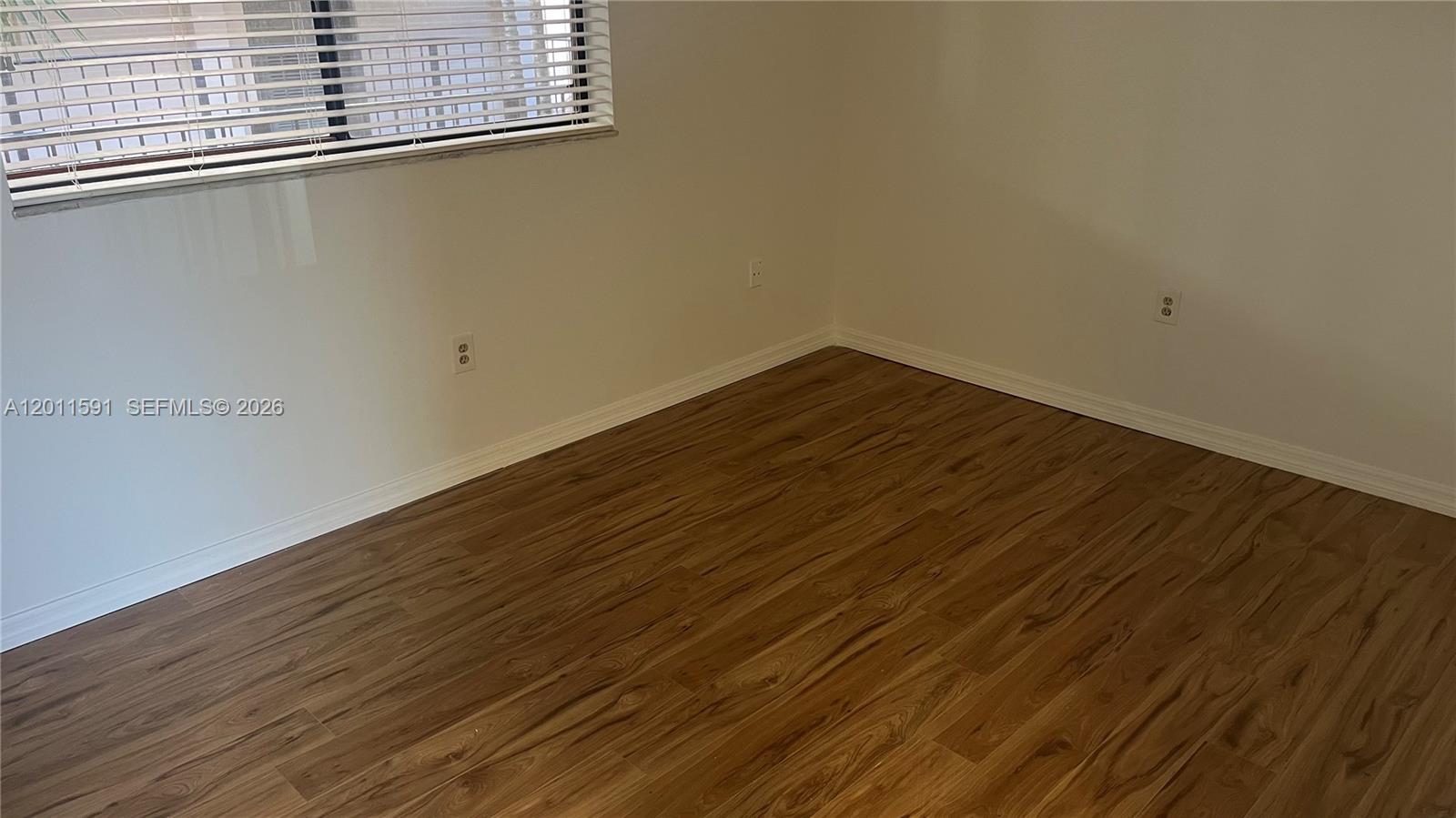 8540 Southwest 133rd Avenue Road, Unit 316 Miami, FL 33183 - Photo 16 of 18 a view of a room with wooden floor and white walls