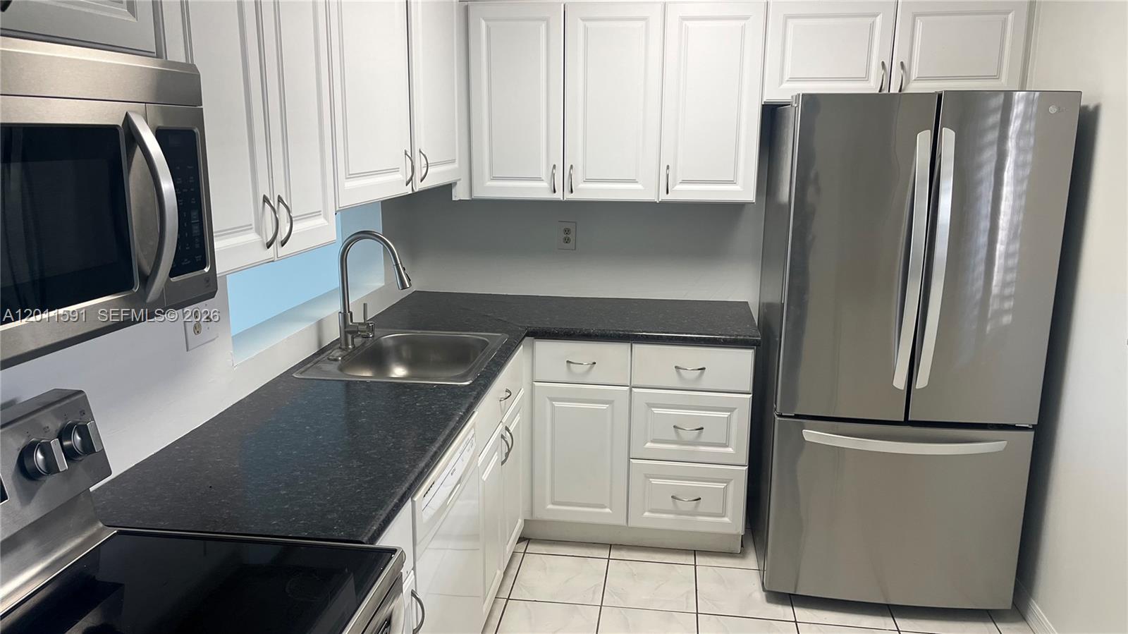 8540 Southwest 133rd Avenue Road, Unit 316 Miami, FL 33183 - Photo 2 of 18 a kitchen with stainless steel appliances a refrigerator and a stove
