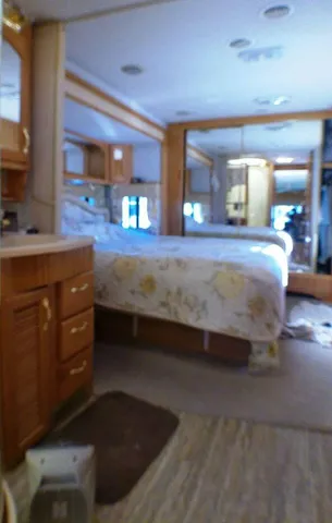 a bedroom with a bed and a large mirror on the dresser