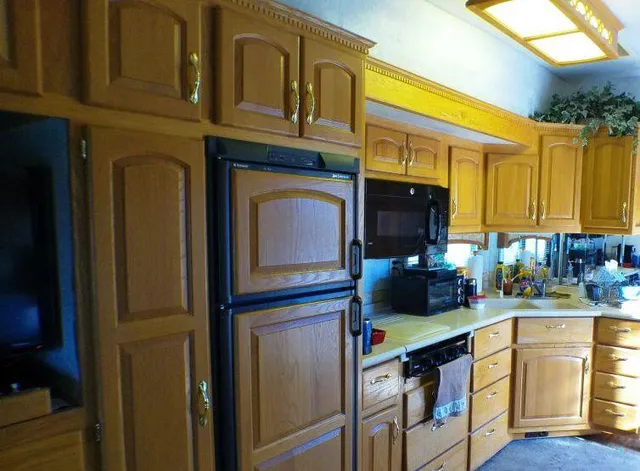 a kitchen with a sink a microwave and cabinets