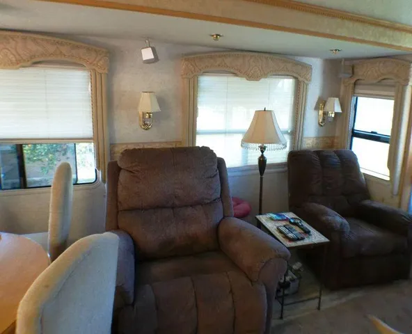 a kitchen with stainless steel appliances granite countertop a dining table chairs refrigerator and a sink