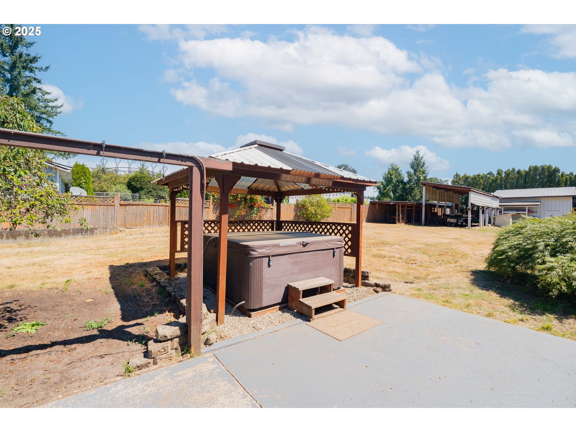 1317 Northeast 267th Avenue Camas, WA 98607 - Photo 35 of 43 a view of a patio with a table and chairs under an umbrella next to a yard