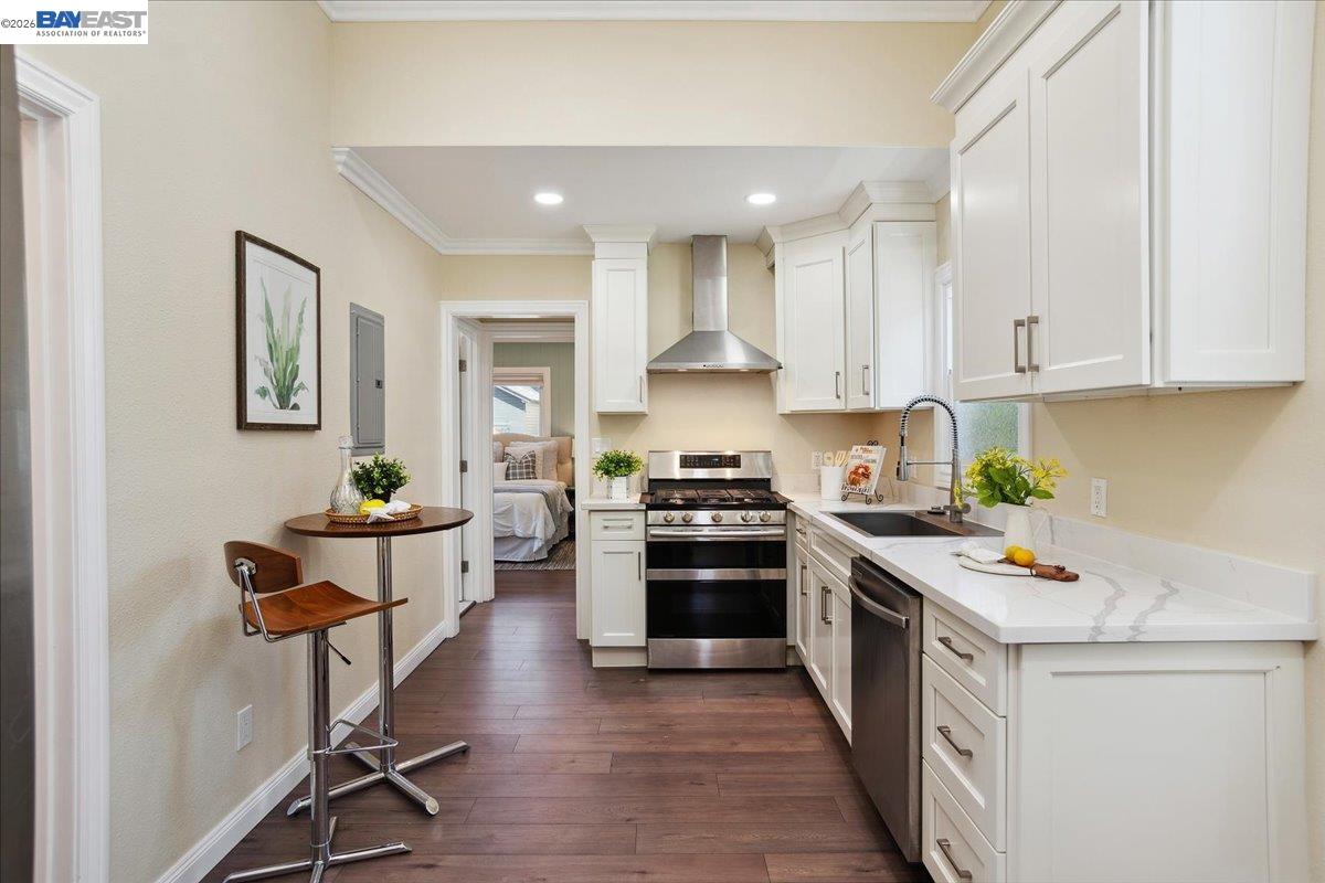 1813 Minturn Street Alameda, CA 94501 - Photo 10 of 29 a kitchen with stainless steel appliances kitchen island granite countertop a stove a sink a refrigerator and white cabinets with wooden floor