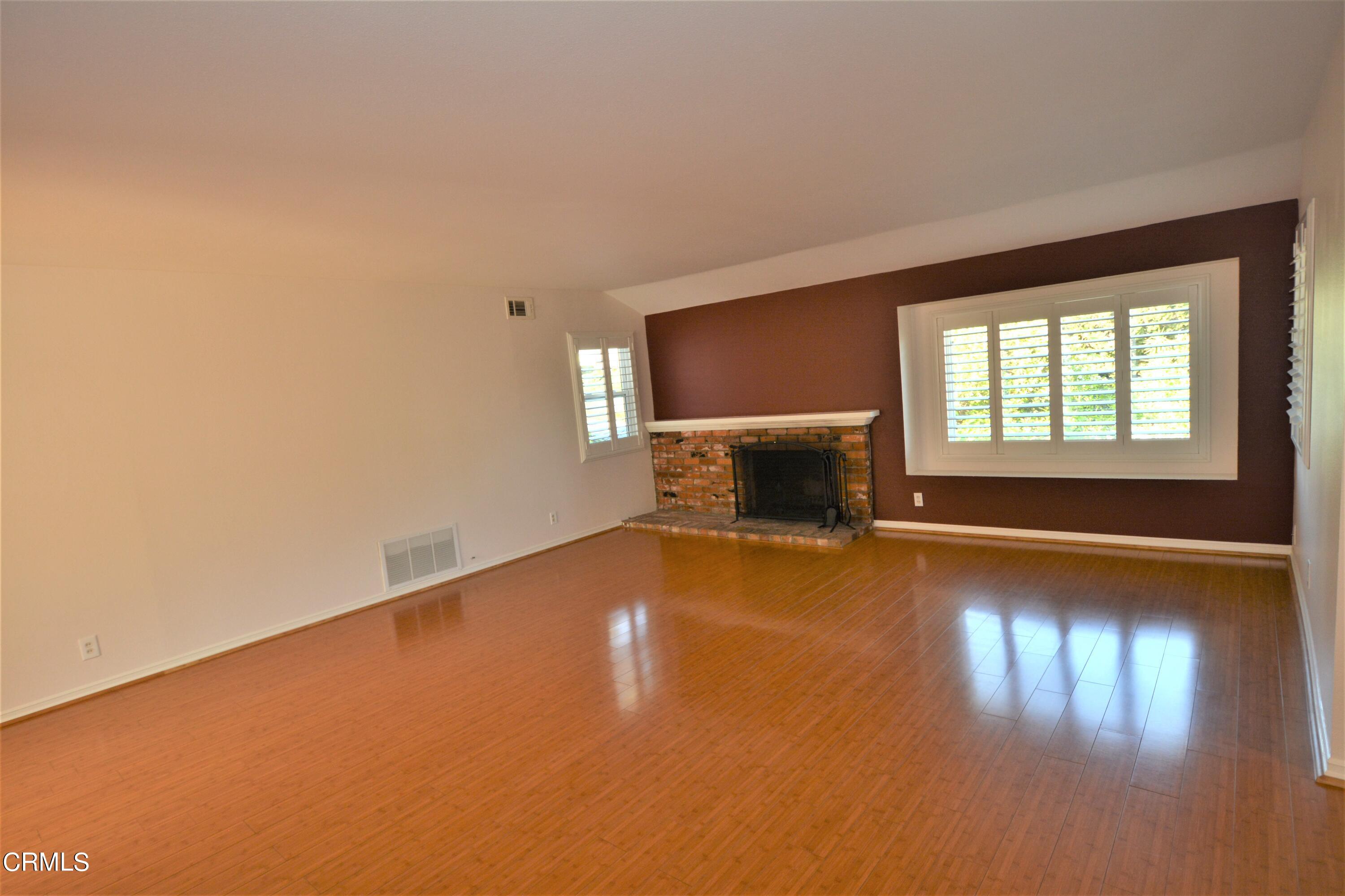 3252 Radcliffe Road Thousand Oaks, CA 91360 - Photo 4 of 31 an empty room with wooden floor fire place and windows