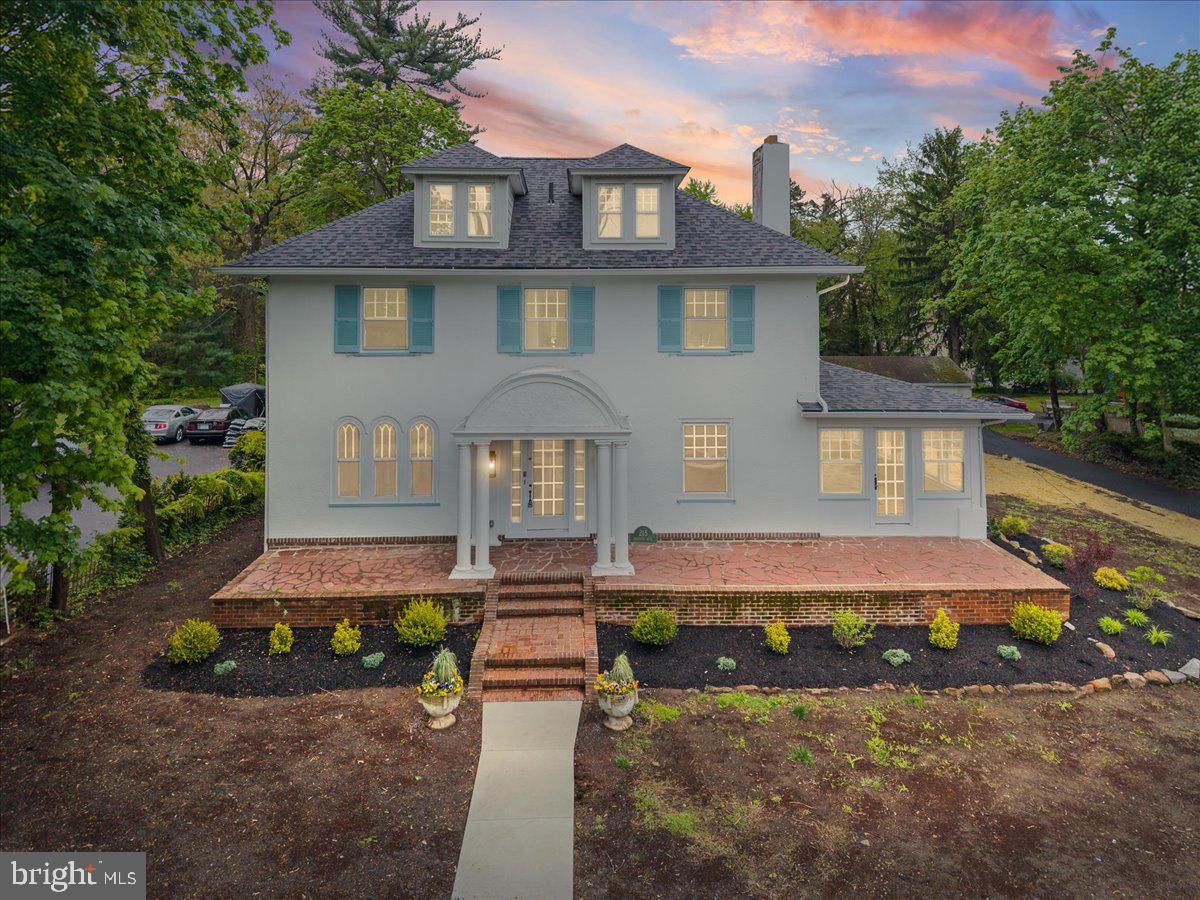 Charming home with lush greenery backdrop.