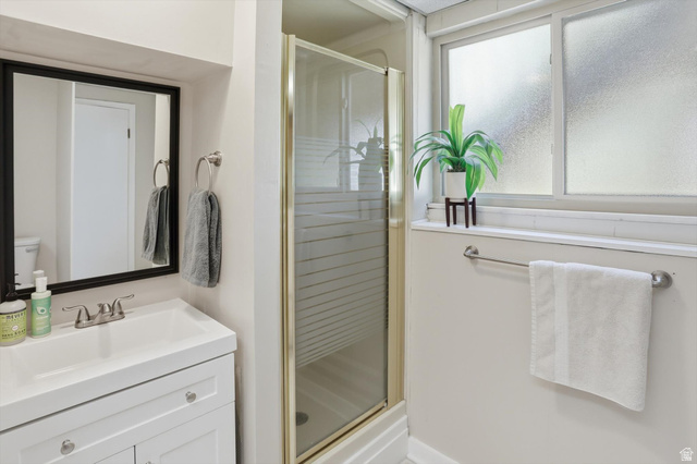 8938 Manchester Lane Sandy, UT 84093 - Photo 30 of 50 White vanity with integrated sink, framed mirror, and chrome fixtures