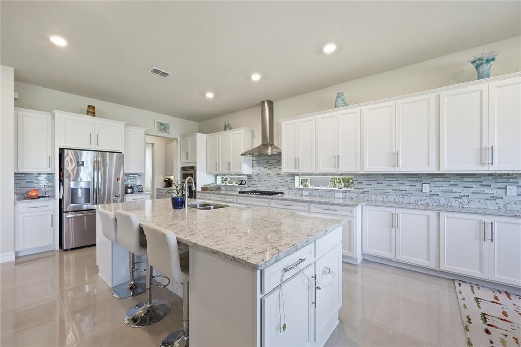 7537 Wandering Way Orlando, FL 32836 - Photo 12 of 71 a kitchen with stainless steel appliances granite countertop a sink stove and refrigerator