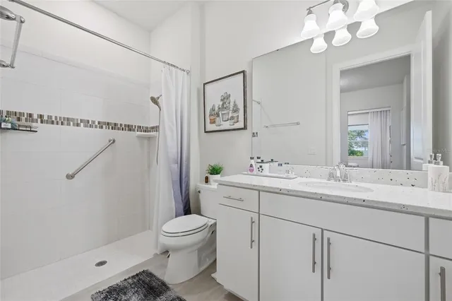 a bed sitting in a spacious bedroom next to a window and a chair