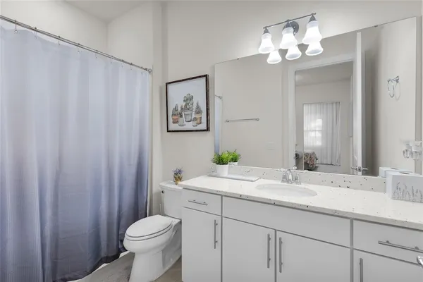 a en suite bathroom with a granite countertop sink and a mirror