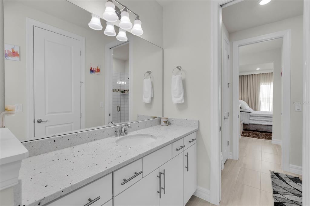 7537 Wandering Way Orlando, FL 32836 - Photo 36 of 71 a spacious bathroom with a granite countertop sink a mirror and a shower