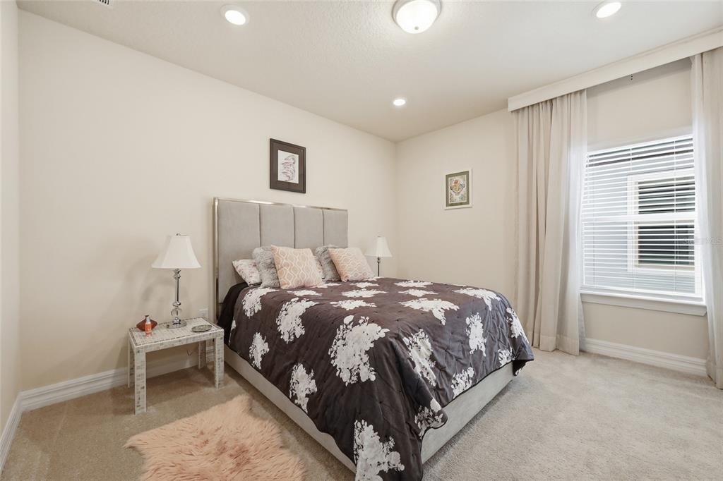 7537 Wandering Way Orlando, FL 32836 - Photo 37 of 71 a bed sitting in a spacious bedroom next to a window and a chair