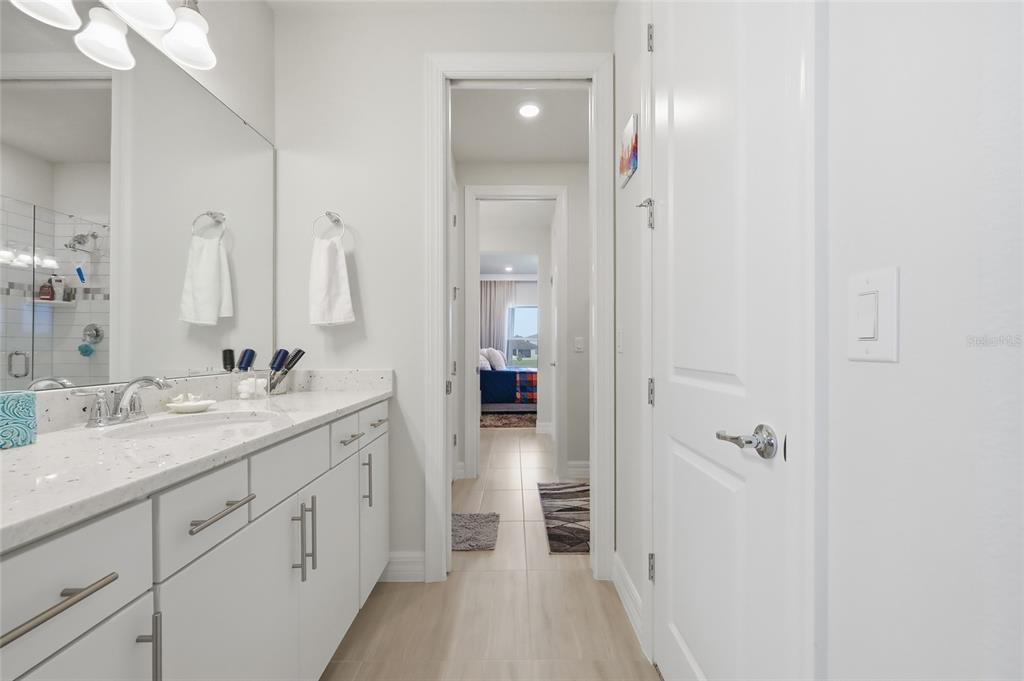 7537 Wandering Way Orlando, FL 32836 - Photo 39 of 71 a en suite bathroom with a granite countertop sink and a mirror