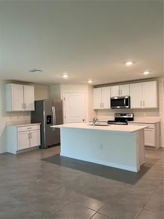 a kitchen with stainless steel appliances a refrigerator sink and white cabinets