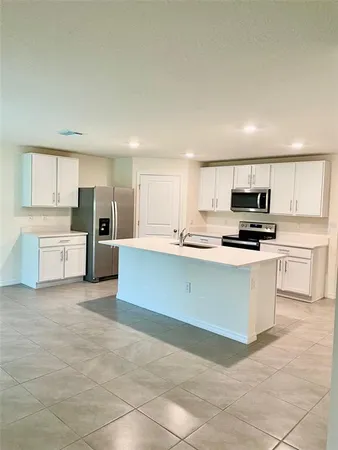 a large kitchen with cabinets and stainless steel appliances