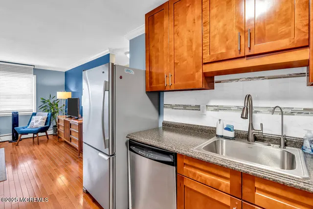 a kitchen with stainless steel appliances granite countertop a sink and a refrigerator