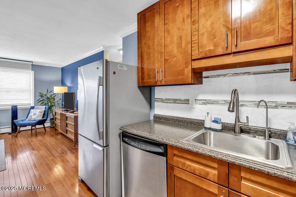 317 8th Avenue, Unit 303 Asbury Park, NJ 07712 - Photo 7 of 15 a kitchen with stainless steel appliances granite countertop a sink and a refrigerator