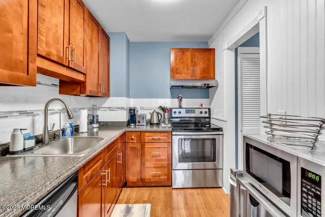 a kitchen with stainless steel appliances granite countertop a stove a sink and a microwave