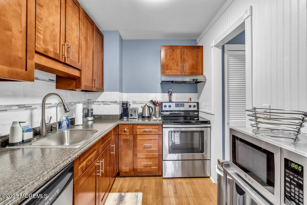 317 8th Avenue, Unit 303 Asbury Park, NJ 07712 - Photo 8 of 15 a kitchen with stainless steel appliances granite countertop a stove a sink and a microwave