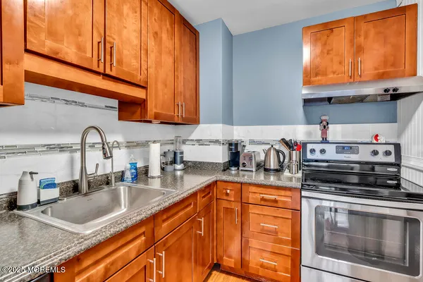 a kitchen with stainless steel appliances granite countertop a sink a stove and cabinets