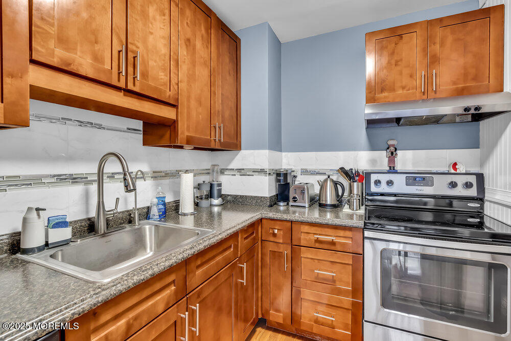 317 8th Avenue, Unit 303 Asbury Park, NJ 07712 - Photo 9 of 15 a kitchen with stainless steel appliances granite countertop a sink a stove and cabinets