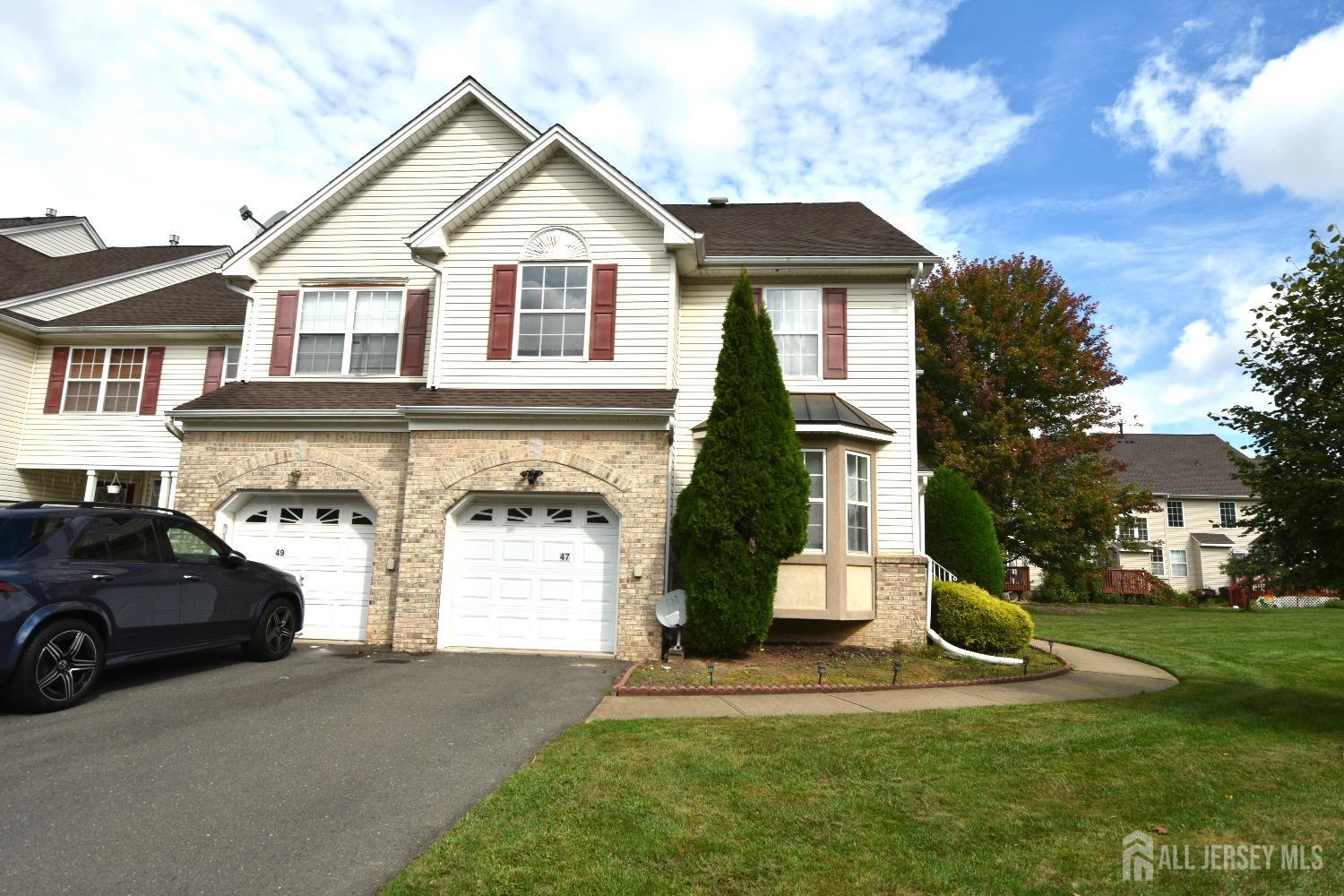 47 Hawthorne Road North Brunswick, NJ 08902 - Photo 1 of 3 a front view of a house with a yard and garage