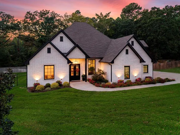 a front view of a house with a yard and trees