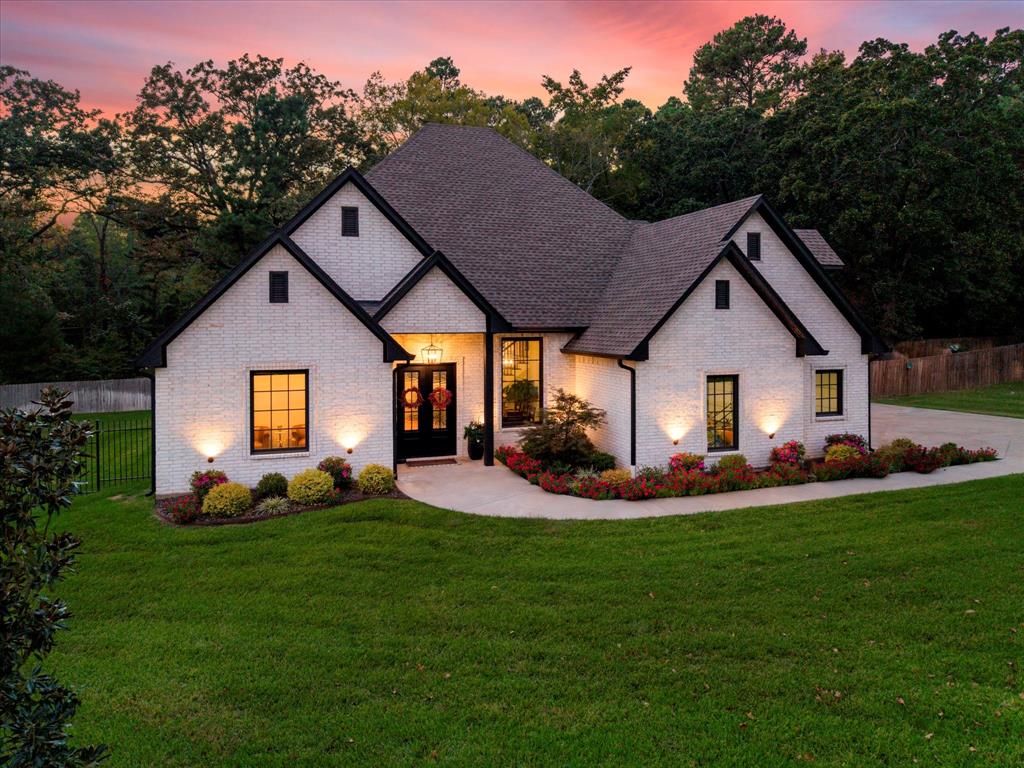 a front view of a house with a yard and trees