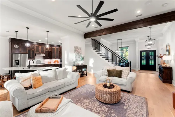 a living room with furniture kitchen view and a chandelier