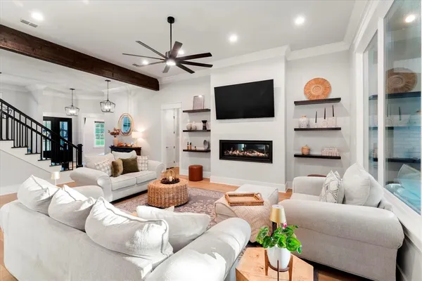 a living room with furniture a flat screen tv and kitchen view