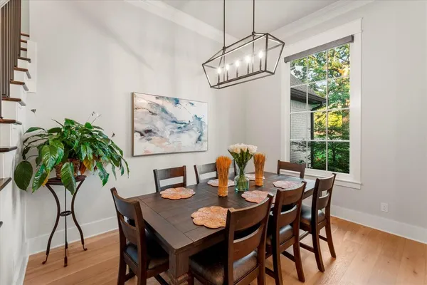 a kitchen with stainless steel appliances kitchen island granite countertop a table chairs and a refrigerator