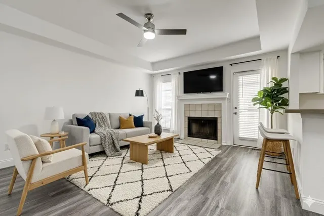 a living room with furniture a flat screen tv and a fireplace