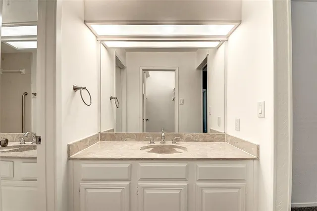 a bathroom with a granite countertop sink a mirror and a vanity
