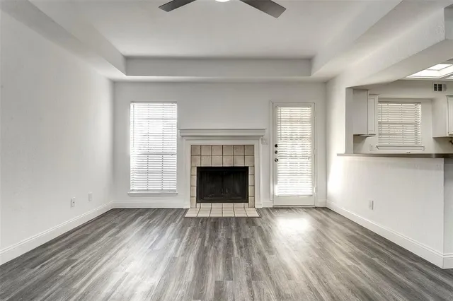 wooden floor fireplace and windows in an empty room